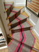 Bold red and black central stripes with natural and charcoal special weave background with red stripes on each edge. Shown here installed on a curved staircase with pie shaped steps and mitered corners. 
