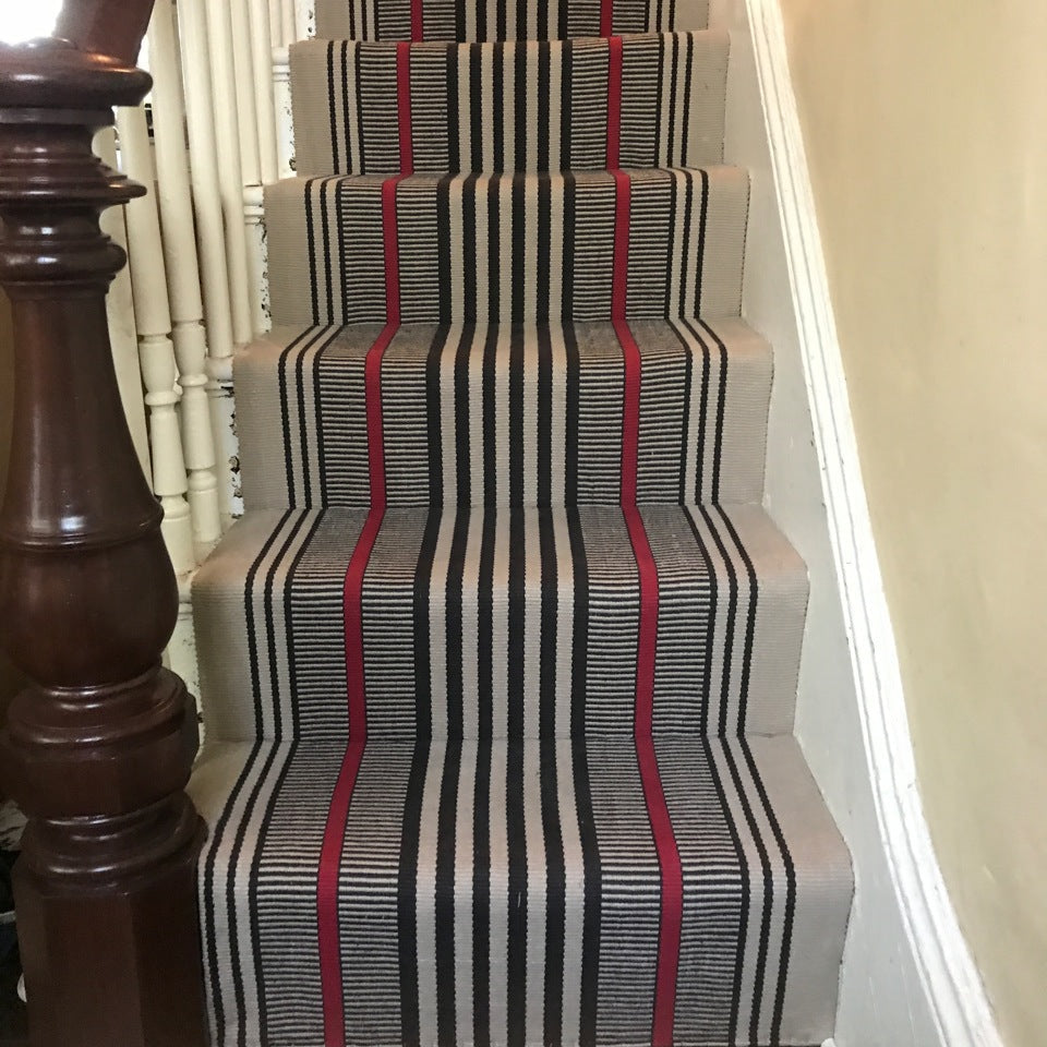 Hamilton #201-R is a bold flat woven rug design with black and red stripe on beige background shown here installed on stairs. 